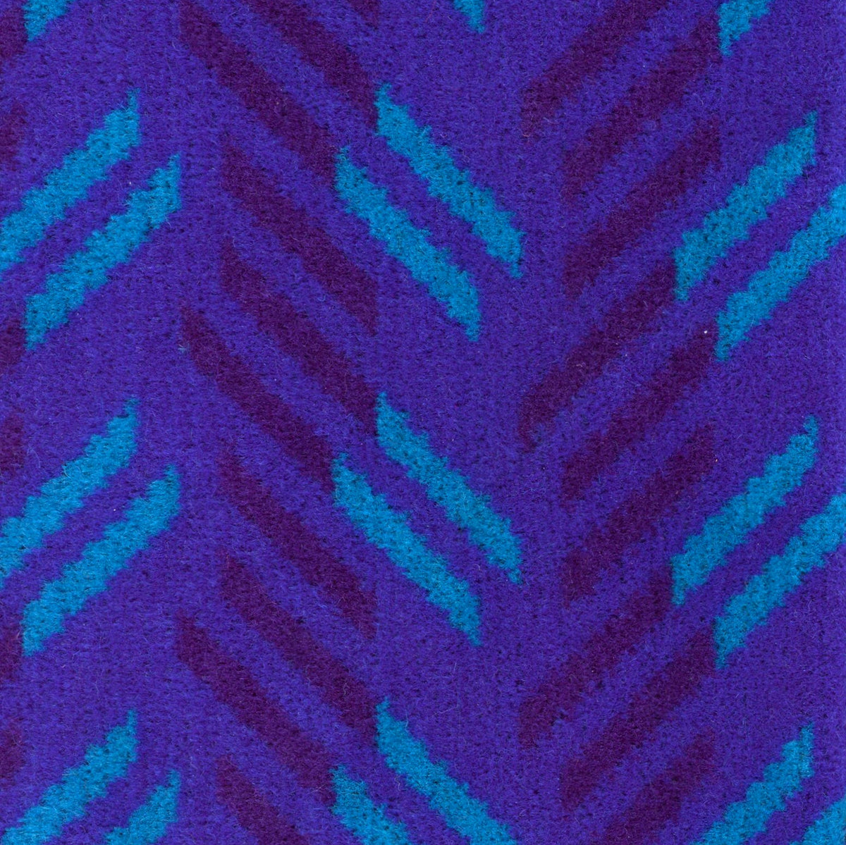 British Rail Network SouthEast Blue Blaze Moquette Fabric Sold by the Metre in bright blue moquette with turquoise and dark purple diagonal stripes.