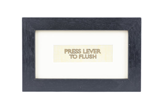 A black frame with a white background and a Press lever to flush gold text on a white plain print background