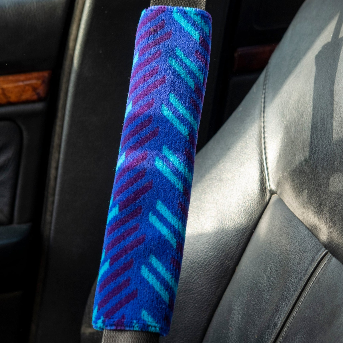 British Rail Network SouthEast Blue Blaze Moquette Seat Belt Pad in bright blue moquette with turquoise and dark purple diagonal stripes.