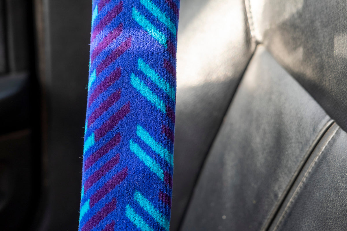 British Rail Network SouthEast Blue Blaze Moquette Seat Belt Pad in bright blue moquette with turquoise and dark purple diagonal stripes.
