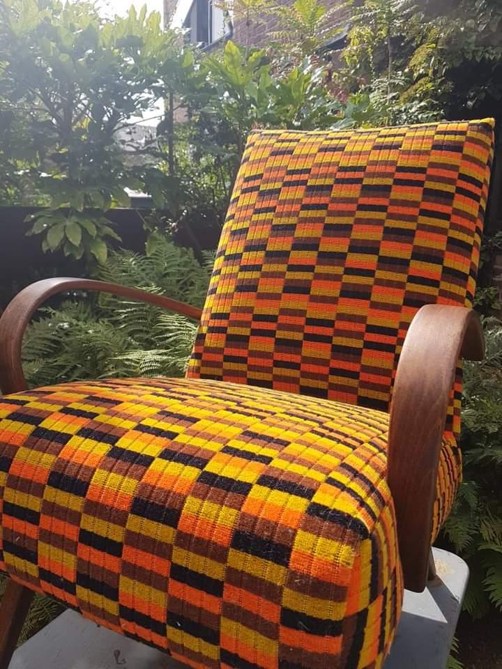 Wooden armchair upholstered in Misha Black orange yellow and brown moquette