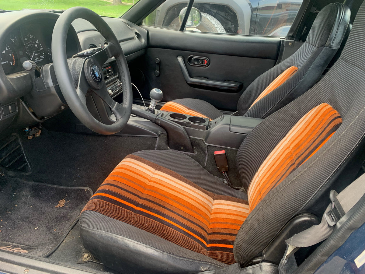 Car interior with seat inserts upholstered in NSE Donkey Stripe First Class moquette