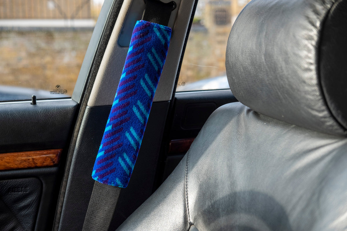 British Rail Network SouthEast Blue Blaze Moquette Seat Belt Pad in bright blue moquette with turquoise and dark purple diagonal stripes.